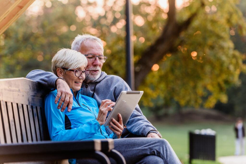 A retired couple smiling as they check the balance on the Roth IRA account they opened many years ago.