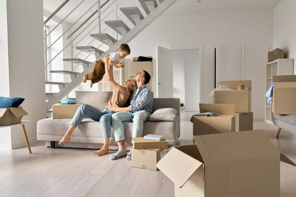 A young couple and their infant child celebrate moving into their new home, made possible with a mortgage loan from Belco Community Credit Union.