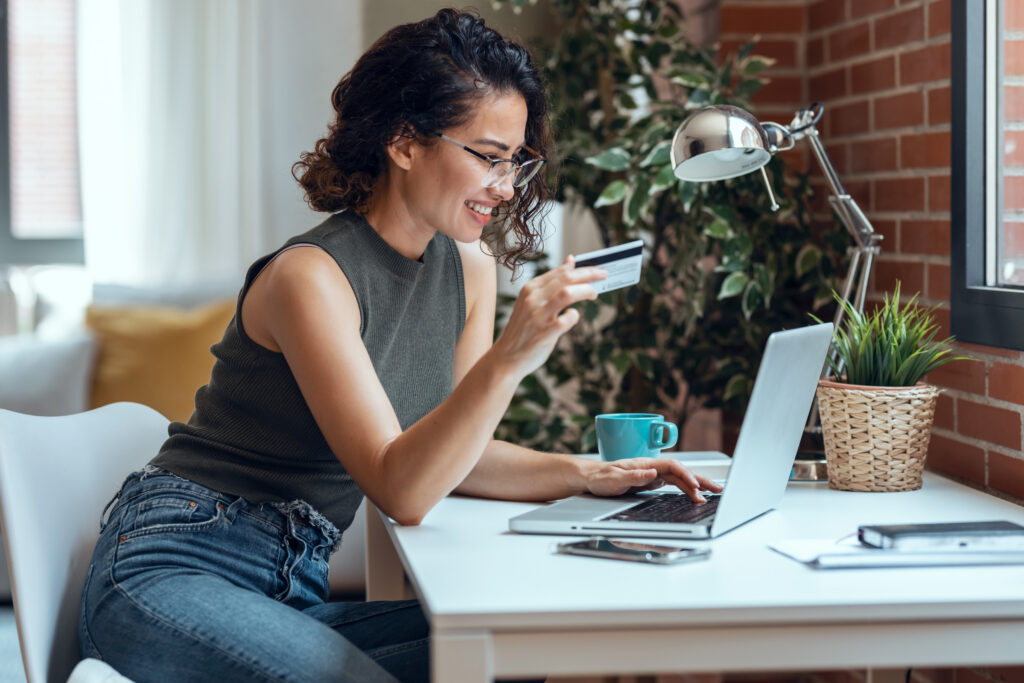 A woman uses her debit card to complete an online purchase