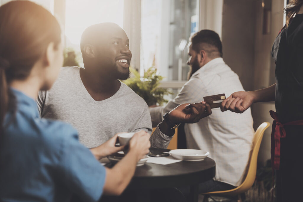 A man paying with a debit card at a café